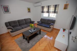 una sala de estar con un sofá y una mesa en Apartman Bokić, en Trebinje