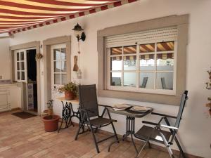 a patio with a table and chairs and a window at Enchanted Villa in Tavira