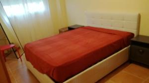 - une chambre avec un lit et une couverture rouge dans l'établissement Nova Almenara. Ideal para familias, à Barrio-Mar