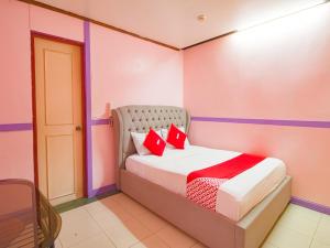 a bedroom with a bed with two red pillows at OYO 790 Mango Inn in Manila