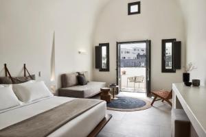 a bedroom with a bed and a living room at Orama Hotel & Spa in Fira
