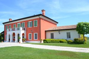 une grande maison rouge et blanche avec une allée. dans l'établissement Villa San Pietro, à Desenzano del Garda