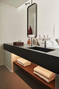 a bathroom with a black sink and a mirror at Orama Hotel & Spa in Fira