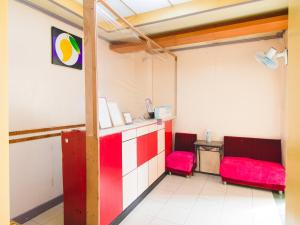 a room with two red chairs and a counter at OYO 790 Mango Inn in Manila