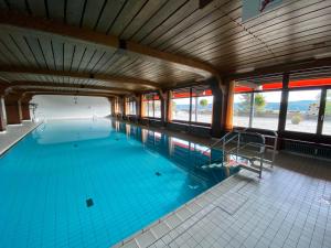 a large swimming pool with blue water at BLACKFOREST LOFT - Panoramablick Schwarzwald in Schonach