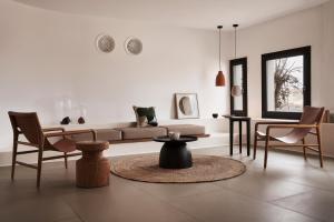 Orama Hotel & Spa في فيرا: غرفة معيشة مع أريكة وكراسي وطاولة