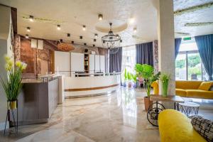 a lobby with a yellow couch and a bar at Aparthotel Primorsko in Primorsko