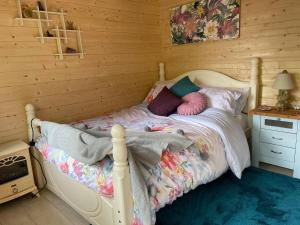 a bedroom with a bed in a wooden room at Woodlands Lodge - come and enjoy the good life in Buckley