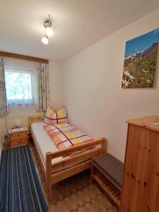 ein kleines Schlafzimmer mit einem Bett und einem Fenster in der Unterkunft Ferienwohnung Prast in Ainet