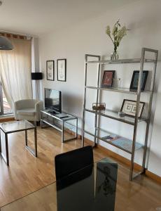 uma sala de estar com uma televisão e uma mesa em Apartamento en la playa em Ribeira