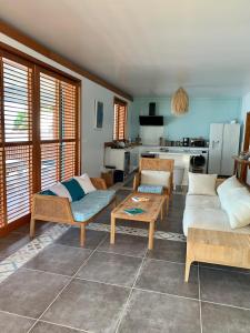 ein Wohnzimmer mit 2 Sofas und einer Küche in der Unterkunft Villa GRENADINE Vue panoramique, les pieds dans l'eau in Terre-de-Haut