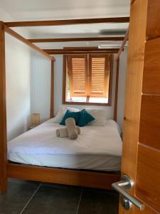 - un lit avec deux oreillers et une fenêtre dans l'établissement Villa GRENADINE Vue panoramique, les pieds dans l'eau, à Terre-de-Haut 14 autres photos