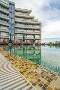 a swimming pool in front of a building at Aparthotel Primorsko in Primorsko