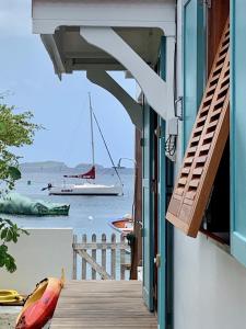 a view of a boat in the water from a house at Villa GRENADINE Vue panoramique, les pieds dans l'eau in Terre-de-Haut