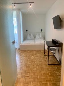 a bedroom with a white bed and a table at Appartement 509 in Klagenfurt
