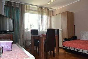 a living room with a dining room table and a bed at Apartman M Bubanj in Kragujevac