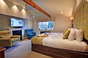a bedroom with a large bed and a fireplace at The Oaksmere in Eye