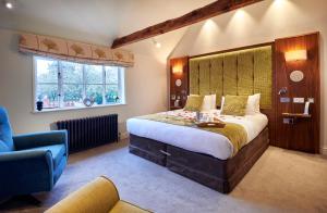 a bedroom with a large bed and a blue chair at The Oaksmere in Eye