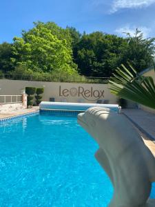 a swimming pool with a statue of a shark in the water at Le Relax in Boulazac