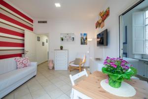 a living room with a couch and a table with flowers at Sami Guest House in Sorrento
