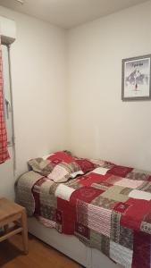 a bedroom with a bed with a quilt on it at Appartement 2 chambres avec jardinet, piscine vue sur la montagne in Luz-Saint-Sauveur