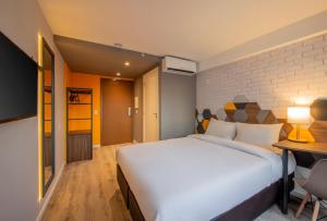 um quarto com uma grande cama branca e uma secretária em B&B HOTEL Rio de Janeiro Norte no Rio de Janeiro