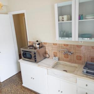 a kitchen with a microwave on top of a counter at Rois Appartments in Poros +39 photos