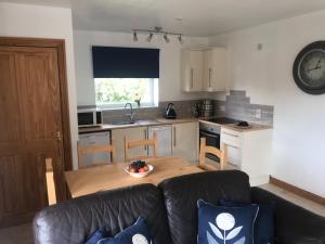 a living room with a couch and a kitchen at Sunnyview Annexe in Saint Briavels