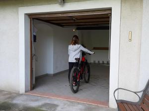 a woman standing next to a bike in a garage at B&B da Sabry e Gian in Comano Terme