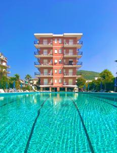 a large swimming pool in front of a building at Perla Marina Apartments in Pietra Ligure