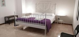 a bedroom with a white bed with a purple blanket at Sant'Ermete in Matino