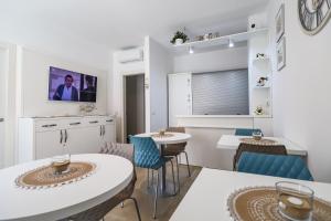 蘭佩杜薩的住宿－Domus B&B Le Nereidi，客厅配有2张桌子和椅子以及电视
