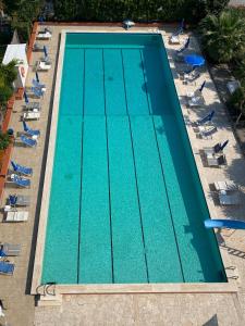 een uitzicht over het zwembad met ligstoelen bij Perla Marina Apartments in Pietra Ligure