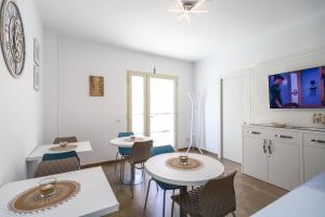 een woonkamer met 2 tafels en stoelen in een kamer bij Domus B&B Le Nereidi in Lampedusa
