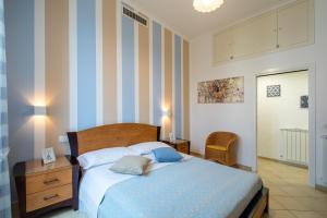 een slaapkamer met een bed en een gestreepte muur bij Sami Guest House in Sorrento
