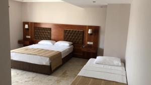 a bedroom with two beds and a wooden headboard at Montana Hotel in Dalyan