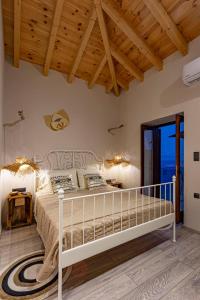 a bedroom with a white bed and a wooden ceiling at Althea Apartments 2 in Halki