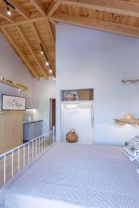 Habitación con cama grande en una habitación con techo de madera. en Althea Apartments 2, en Halki