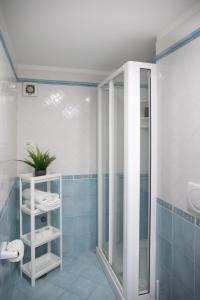 a blue tiled bathroom with a shower and a toilet at Sami Guest House in Sorrento +21 photos