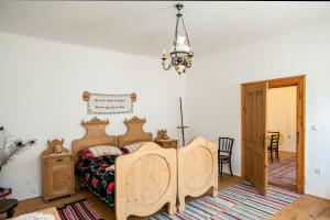 a bedroom with a wooden bed and a chandelier at Villa Rihuini Eco Wine house Transylvania in Richişu