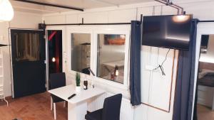 a room with a white table and a tv on a wall at Cosy Novi Sad loft, self check-in in Petrovaradin