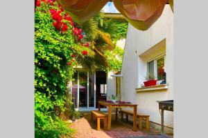 a patio with a table and benches in front of a house at Villa Lilly 2 piscine et jardin privé 8 chambres in Pierry
