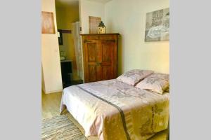 a bedroom with a bed and a wooden cabinet at Villa Lilly 2 piscine et jardin privé 8 chambres in Pierry +29 photos