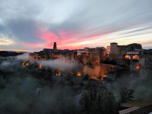 a view of a city at sunset with fog at Zaccheo 9 in Pitigliano