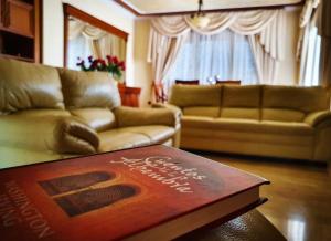 - un salon avec un canapé et un livre sur une table dans l'établissement Villa Tres Palmeras en Alfaz del Pi , Albir, Benidorm, à L'Alfàs del Pi