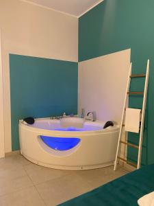 a bath tub in a room with a blue accent wall at fiori catene tra le torri in Conversano +115 photos