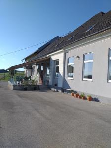 Un bâtiment blanc avec beaucoup de fenêtres et de plantes dans l'établissement Apartma Sveti Duh, à Nova Vas