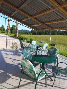 un groupe de tables et de chaises sous un toit dans l'établissement Apartma Sveti Duh, à Nova Vas