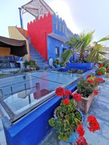 een gebouw met blauwe en rode muren en wat bloemen bij Bayt Alice Hostel in Tanger