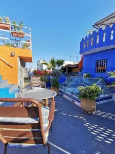 een terras met een tafel en stoelen en een blauw gebouw bij Bayt Alice Hostel in Tanger